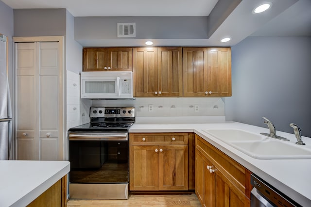 kitchen with stainless steel electric range oven, dishwasher, sink, and decorative backsplash