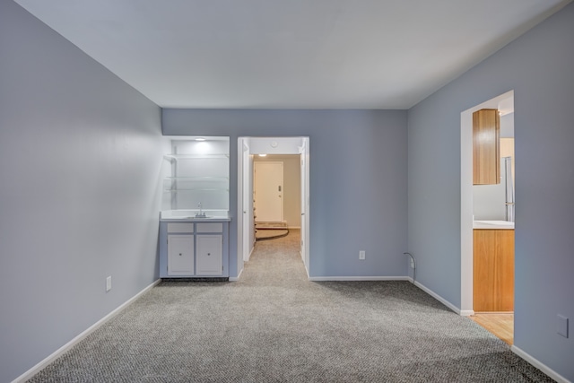 unfurnished bedroom with sink and light colored carpet