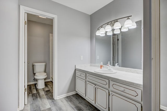 bathroom with vanity, hardwood / wood-style flooring, and toilet