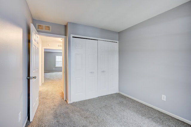 unfurnished bedroom with a closet and carpet flooring