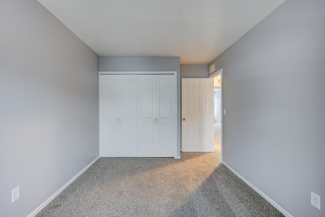 unfurnished bedroom featuring carpet and a closet