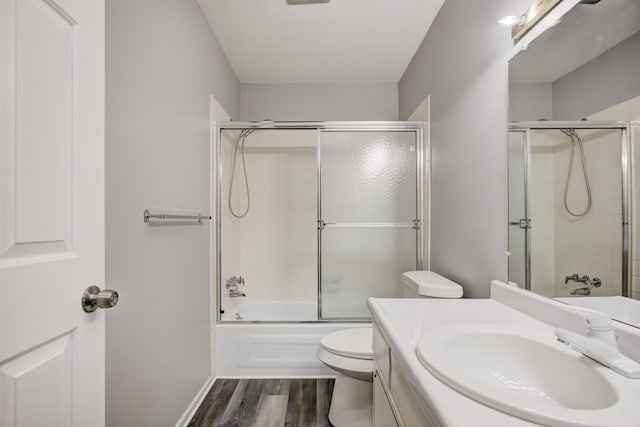 full bathroom featuring enclosed tub / shower combo, wood-type flooring, vanity, and toilet