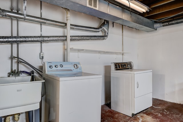 laundry room with separate washer and dryer and sink