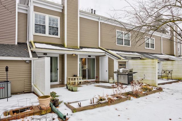 snow covered rear of property with cooling unit