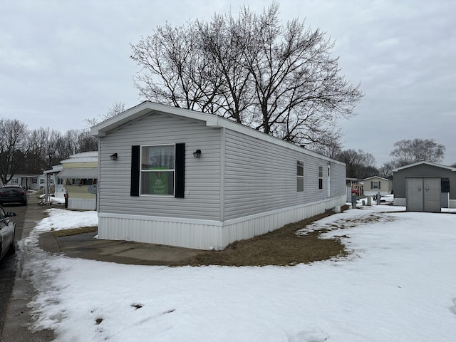 view of snow covered exterior featuring a storage shed