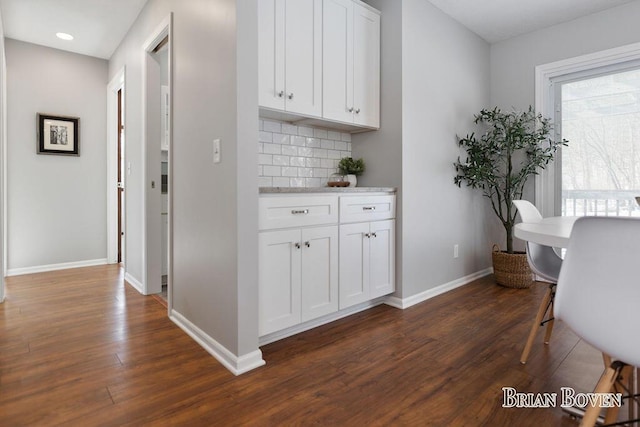 interior space featuring white cabinetry, dark wood-type flooring, and tasteful backsplash