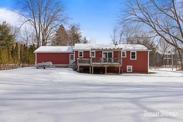 snow covered rear of property with a wooden deck