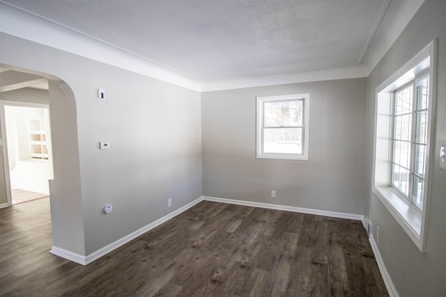 spare room with dark wood-type flooring and a textured ceiling