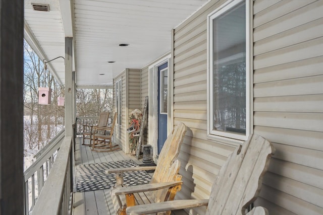 snow covered deck with a porch