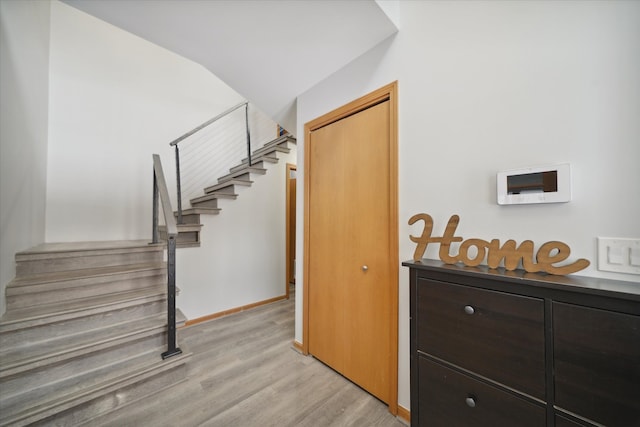 stairs with vaulted ceiling and hardwood / wood-style floors