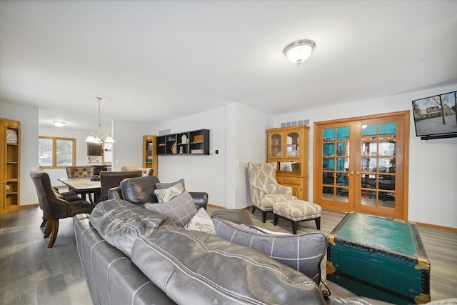 living room with hardwood / wood-style flooring, a notable chandelier, and french doors