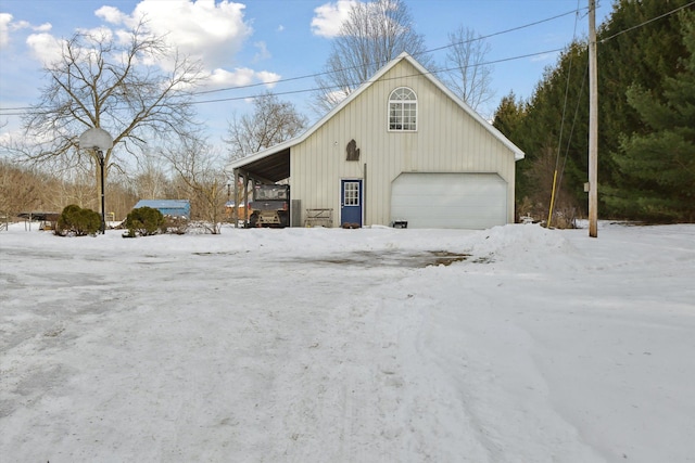 snow covered property with an outbuilding and a garage