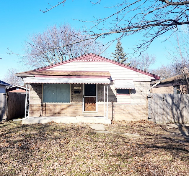 exterior space featuring brick siding and fence