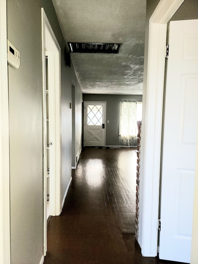 corridor featuring dark hardwood / wood-style floors and a textured ceiling