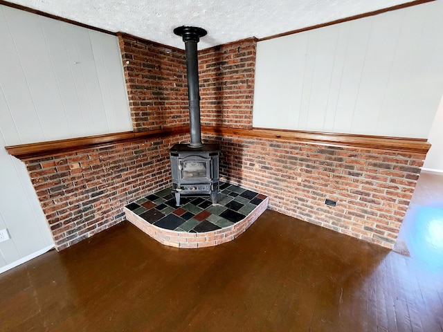 interior details with a wood stove, hardwood / wood-style floors, and a textured ceiling