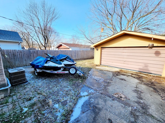 view of yard featuring cooling unit, a garage, and an outdoor structure