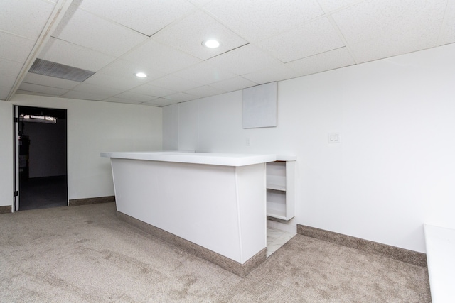 bar featuring white cabinetry, a paneled ceiling, and light colored carpet