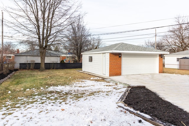 snow covered garage with a lawn