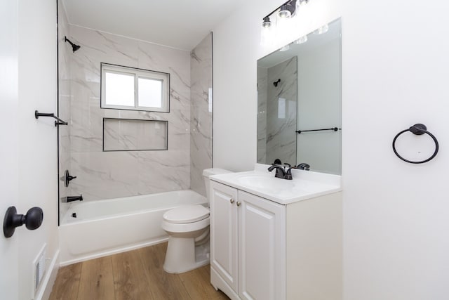 full bathroom with hardwood / wood-style flooring, vanity, toilet, and tiled shower / bath combo