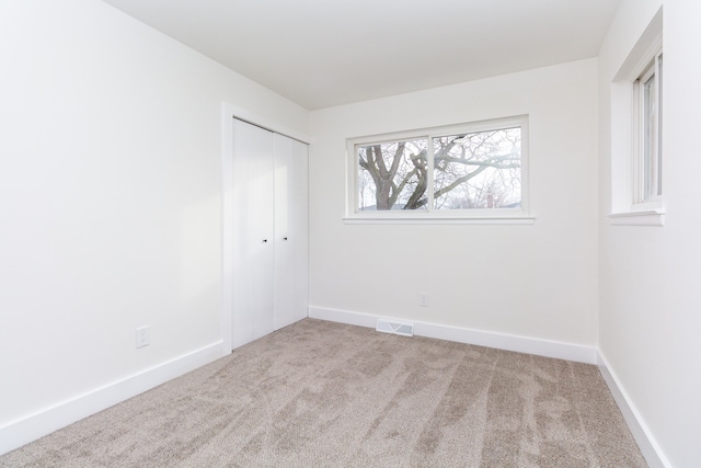 empty room featuring light colored carpet