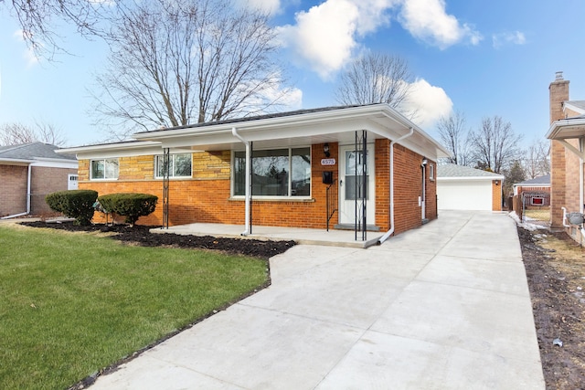 single story home with an outbuilding, a garage, and a front lawn