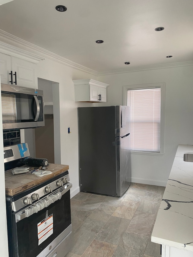 kitchen featuring ornamental molding, white cabinets, and appliances with stainless steel finishes