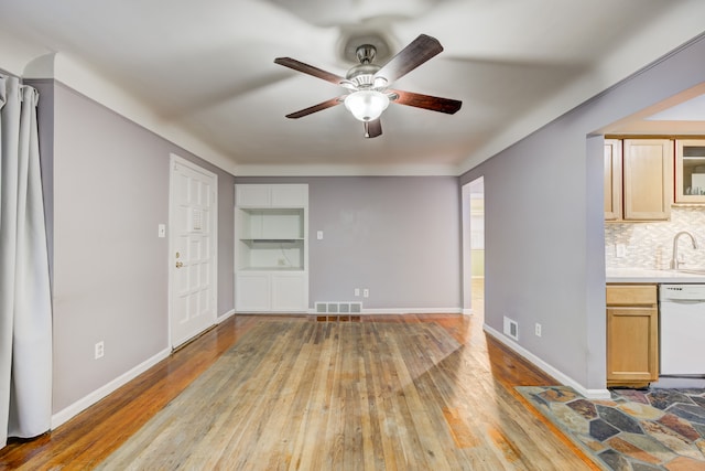 unfurnished living room featuring ceiling fan, sink, and light wood-type flooring