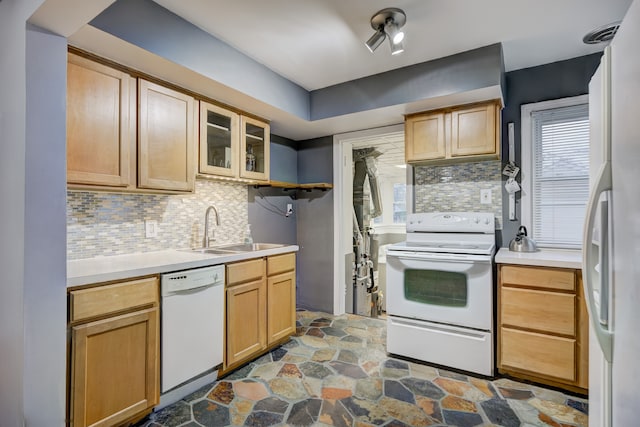 kitchen with white appliances, light brown cabinetry, sink, and backsplash