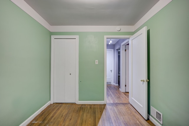 unfurnished bedroom featuring hardwood / wood-style floors and a closet