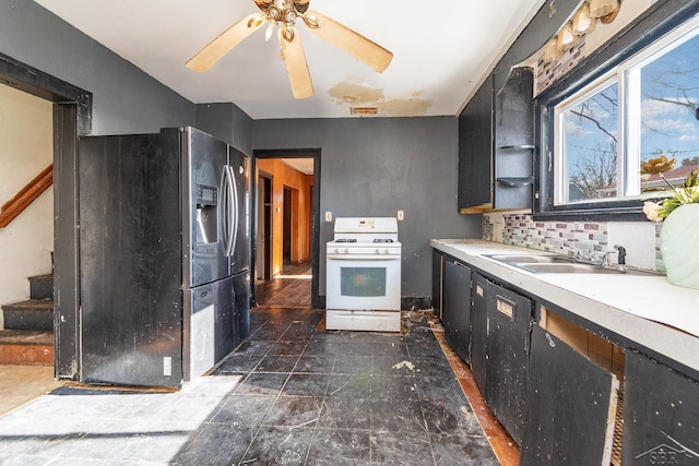 kitchen with sink, backsplash, gas range gas stove, ceiling fan, and stainless steel fridge with ice dispenser