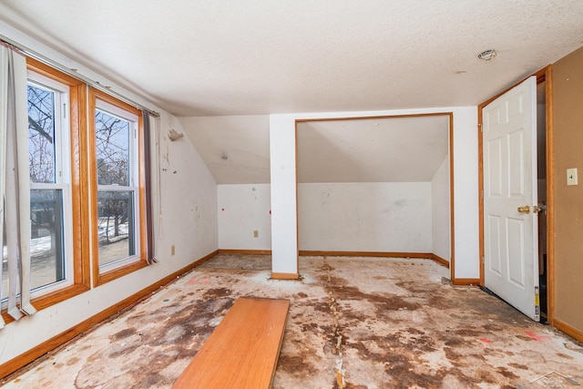 bonus room with vaulted ceiling and a textured ceiling