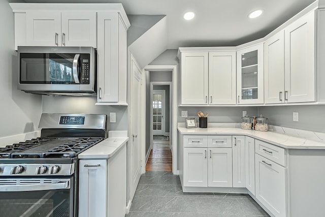 kitchen with light stone counters, white cabinets, and appliances with stainless steel finishes