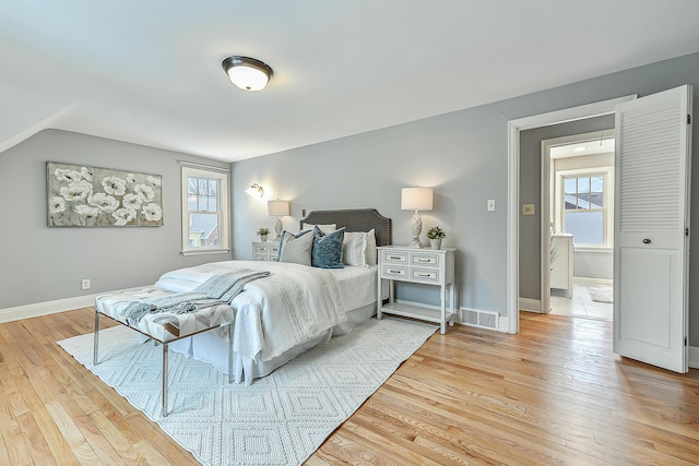 bedroom featuring lofted ceiling and light hardwood / wood-style flooring