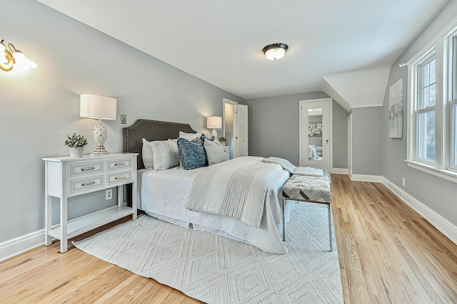 bedroom with vaulted ceiling and light wood-type flooring