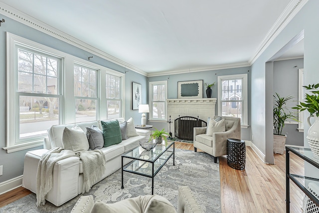 living room with wood-type flooring, a brick fireplace, and ornamental molding