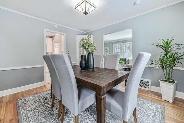 dining area featuring crown molding and hardwood / wood-style floors