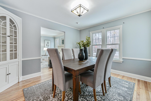 dining space featuring light hardwood / wood-style flooring and ornamental molding