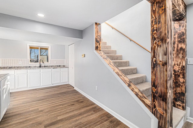 staircase with sink and hardwood / wood-style flooring