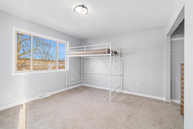 unfurnished bedroom with carpet floors and a textured ceiling