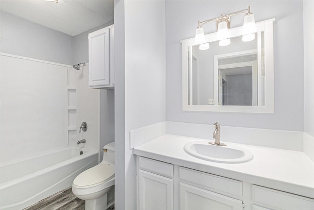 full bathroom with  shower combination, toilet, hardwood / wood-style floors, and vanity