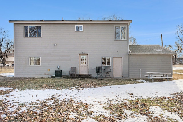 snow covered property featuring central AC