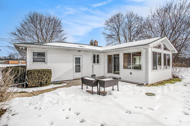 view of snow covered back of property