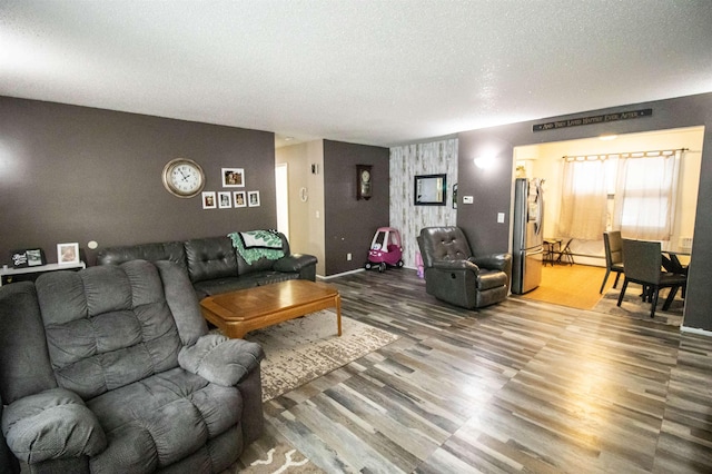 living room with hardwood / wood-style flooring, a baseboard radiator, and a textured ceiling