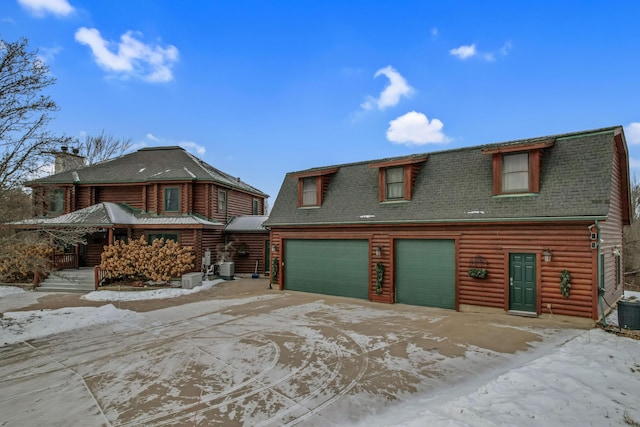 log home with a garage and central air condition unit