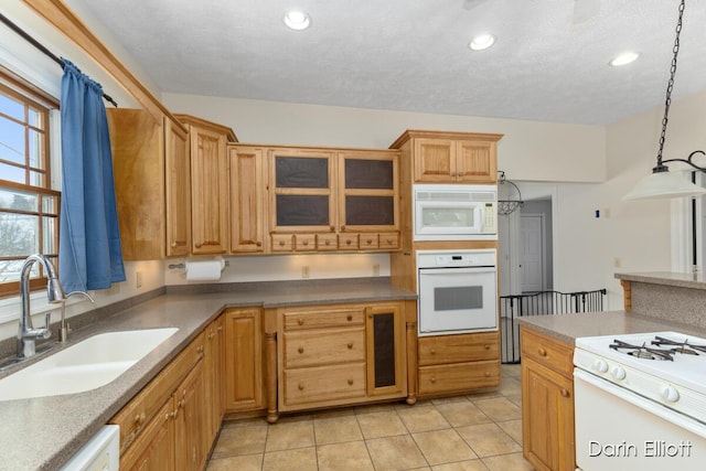 kitchen with sink, hanging light fixtures, light tile patterned floors, white appliances, and a textured ceiling