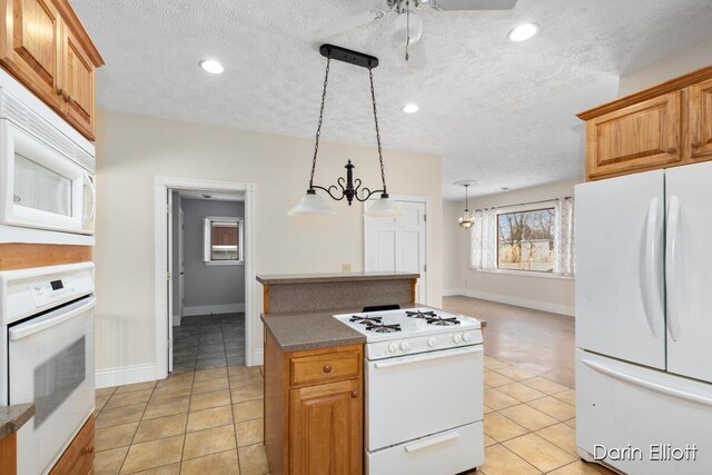 kitchen with white appliances, ceiling fan, hanging light fixtures, a textured ceiling, and light tile patterned flooring