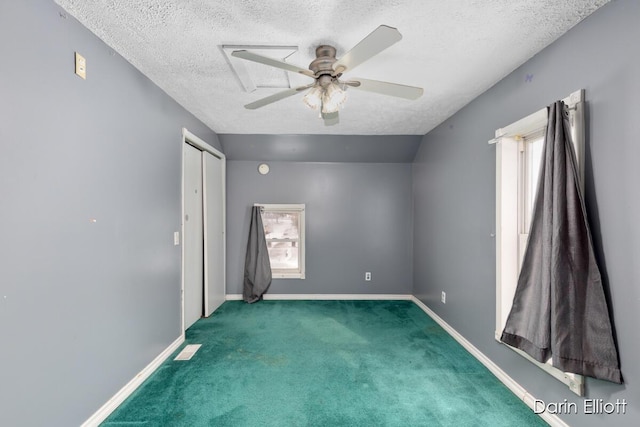 carpeted empty room featuring ceiling fan and a textured ceiling