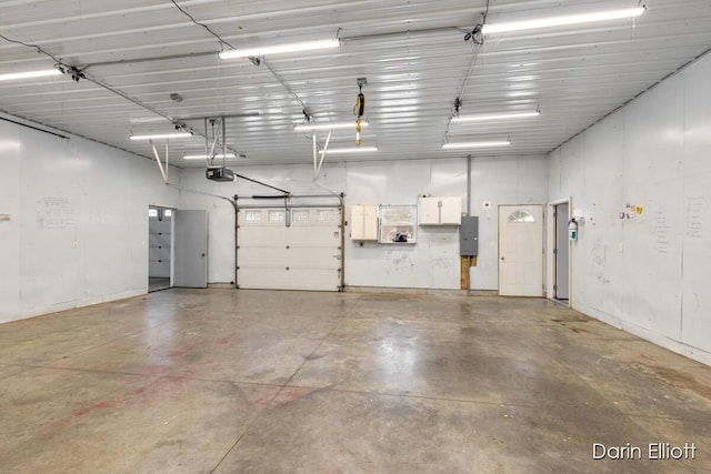 garage with a garage door opener and electric panel