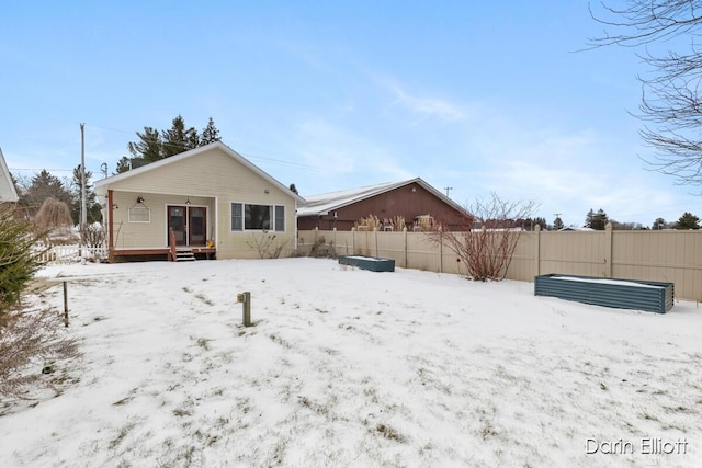 view of snow covered rear of property