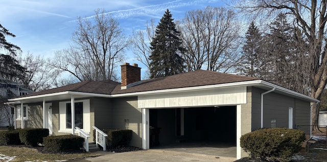 view of property exterior with concrete driveway, a shingled roof, a garage, concrete block siding, and a chimney